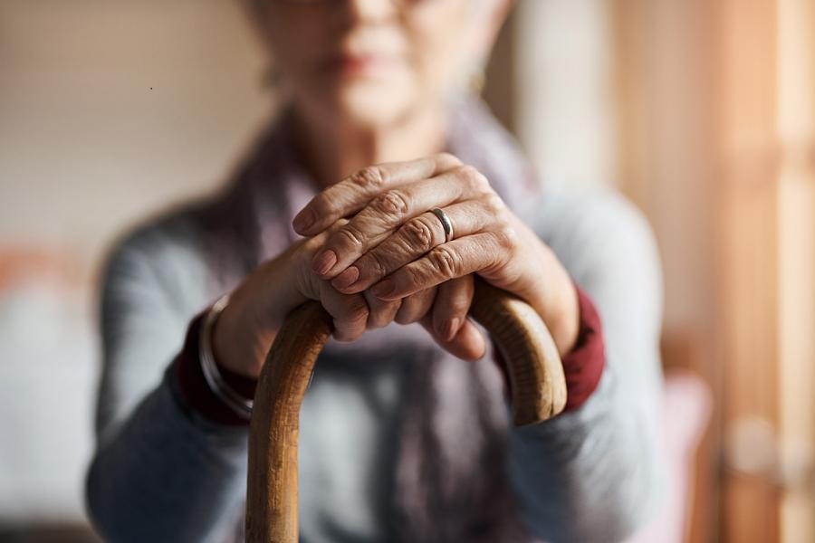 Cropped shot of a senior woman holding a cane in front of her