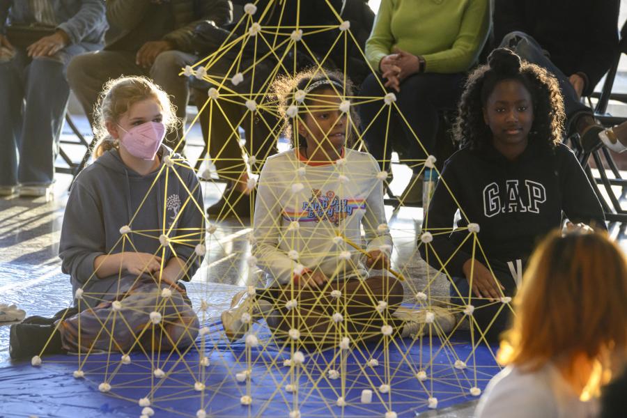 A trio of students participates in the Tower of Power competition using raw spaghetti and marshmallows