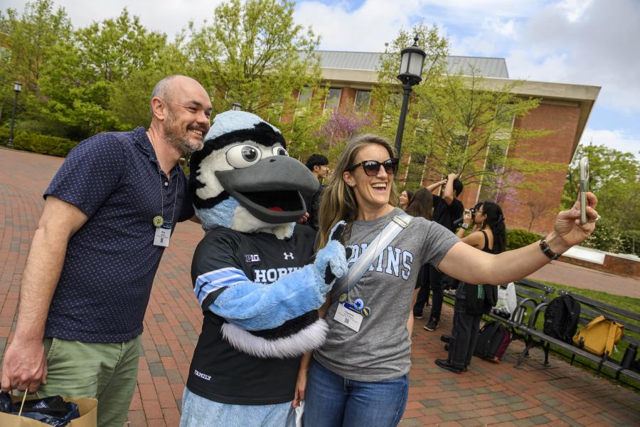 People take a selfie with Jay the Hopkins mascot