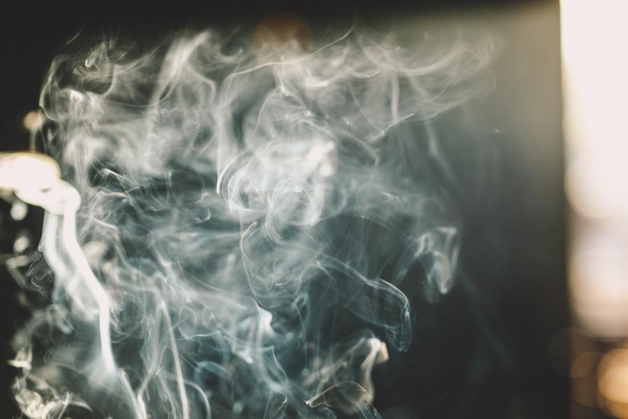A wispy cloud of smoke with light shining through it