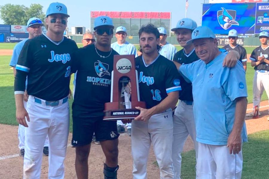 Hopkins baseball players and coach pose with NCAA runner-up trophy
