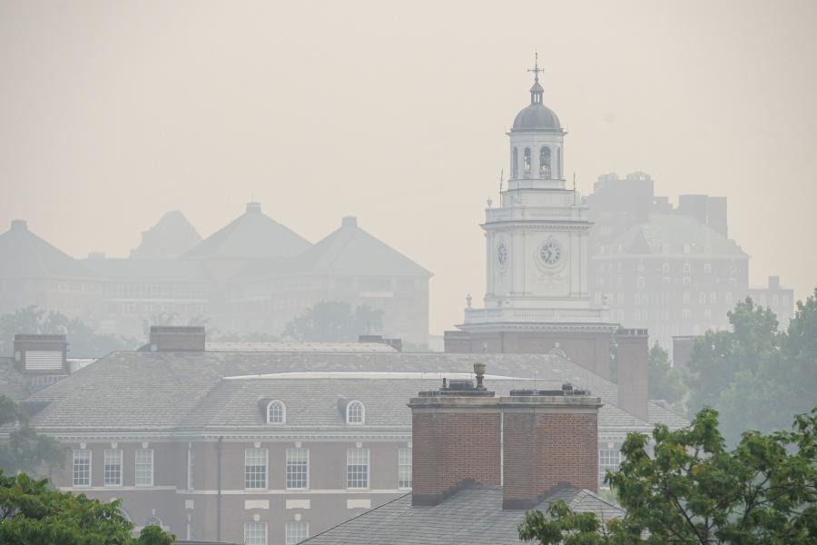 The tops of campus buildings are seen through a thick, dense smoke