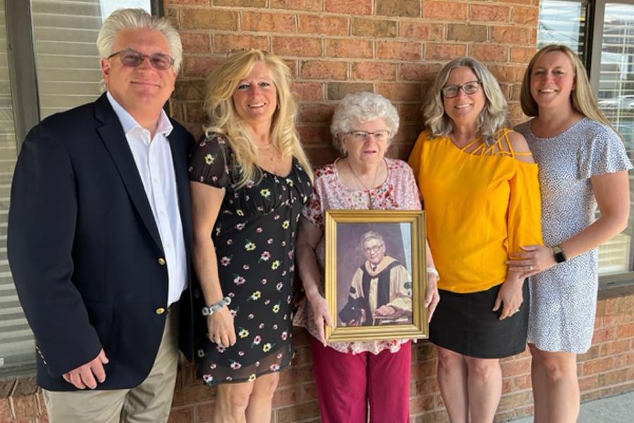 Five family members: John Bourgeois Jr., Jeannine Bourgeois Wills, Betty Michel Bourgeois with a photograph of the late John Bourgeois Sr. (taken when he received his doctorate in environmental engineering), Michelle Bourgeois Johnson, and Lauren J. Brusak. 
