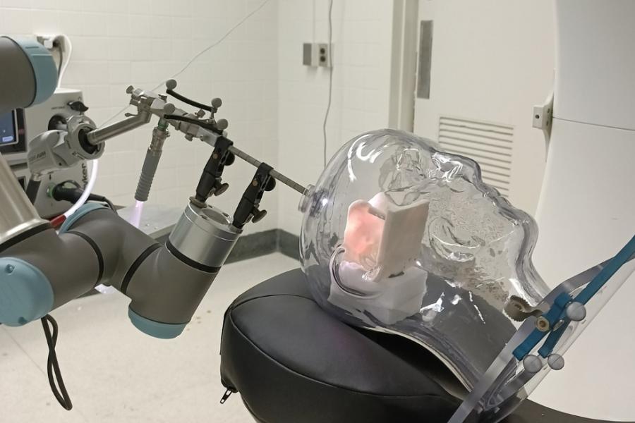 A robotic surgical device demonstrates a brain operation technique on a clear mannekin head
