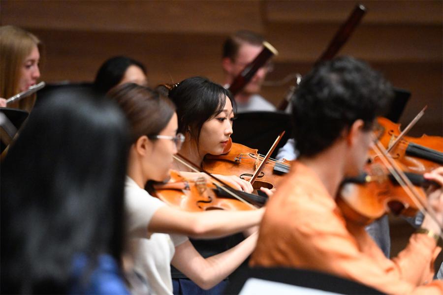 A violin section with one violinist in focus in the center