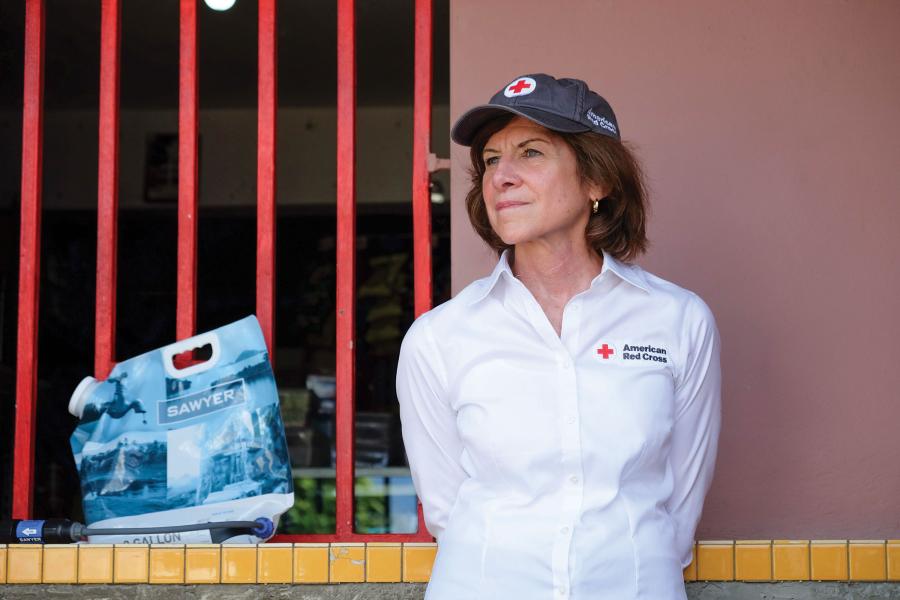 Gail McGovern looks into the distance, while wearing a Red Cross branded hat and button-down shirt