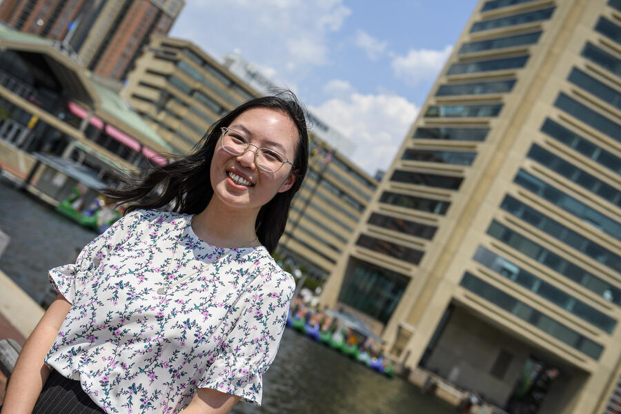 Julia Ye outside the World Trade Center in Baltimore on a sunny summer day with blue skies