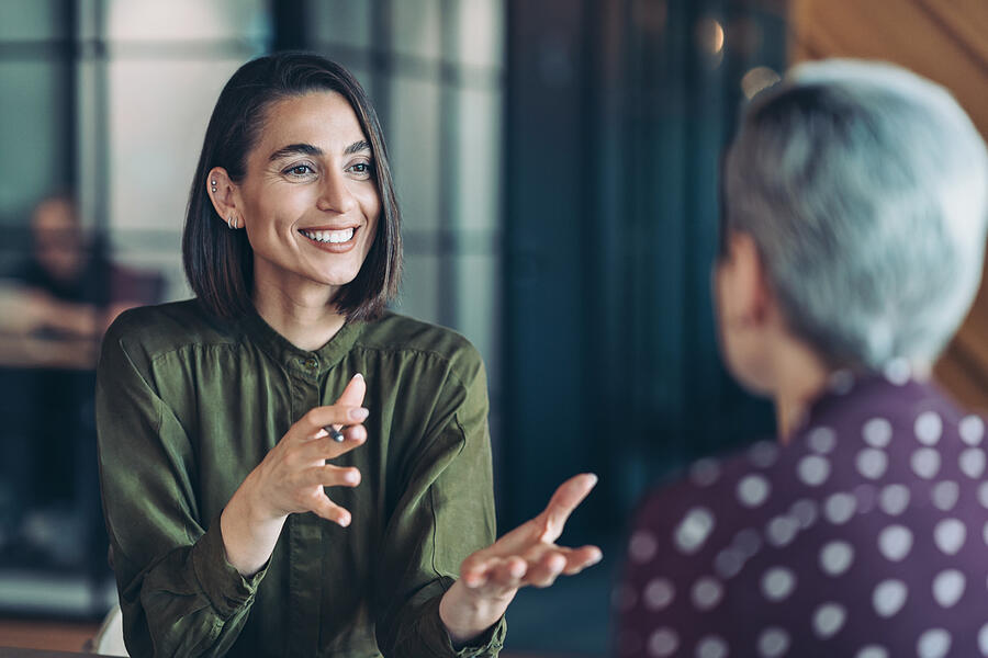 A female manager having a friendly conversation with one of her reports.