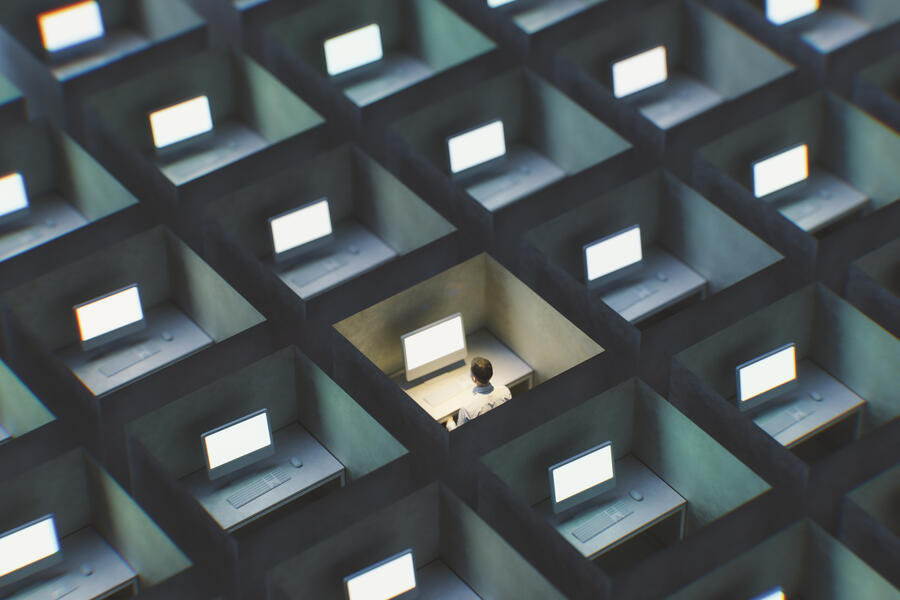 Surreal image of office cubicles with a person working late