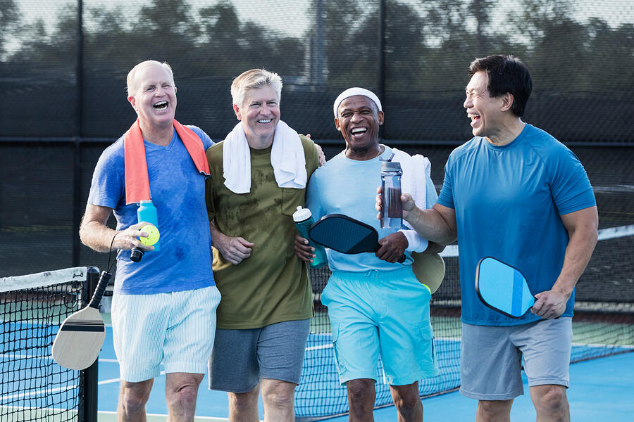 Four senior men on a paddleball court