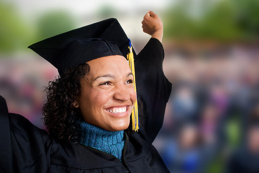 Jubilant mature woman in graduation cap and gown