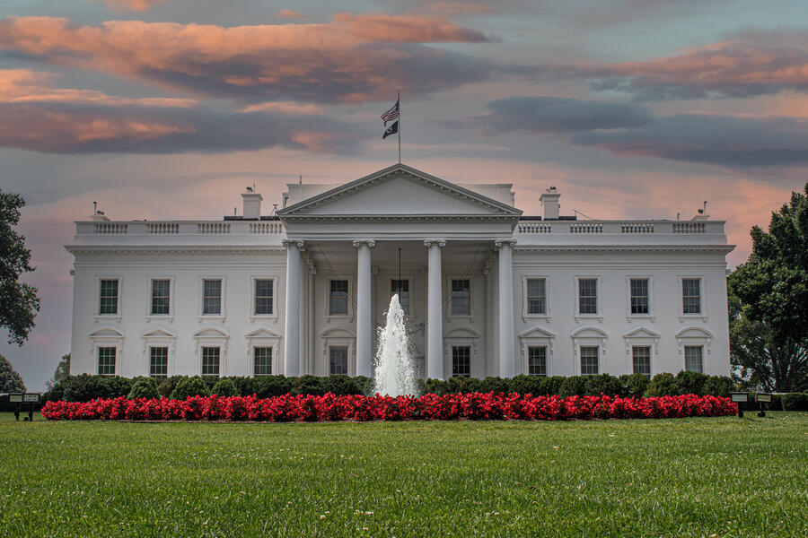 A photograph of the White House at dusk.