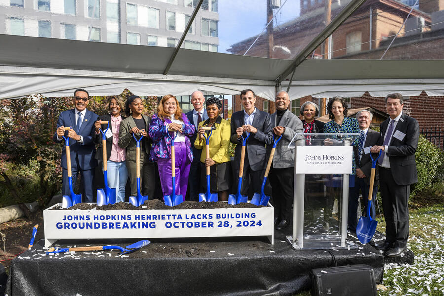 A group of individuals with shovels pose for a photo