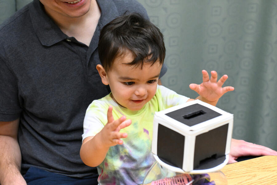 A toddler reacts to selecting a toy from the machine, during the experiment.