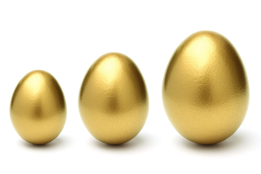 Three gold eggs of increasing sizes, indicating growth in savings