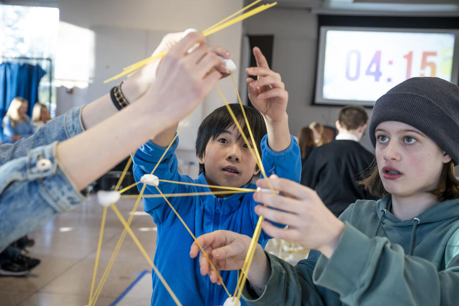 Two students build a spaghetti tower