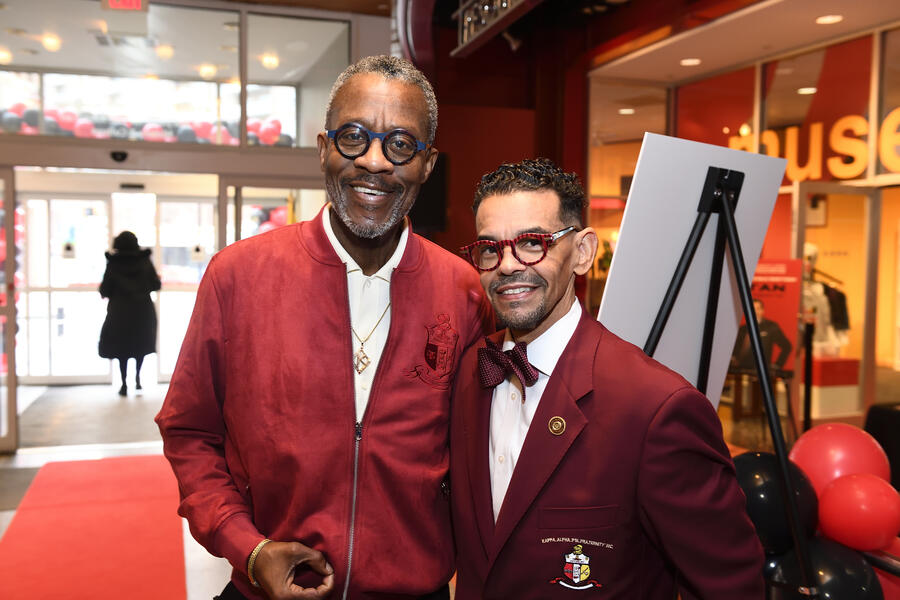 Two adults smile for the camera. Both are wearing red.