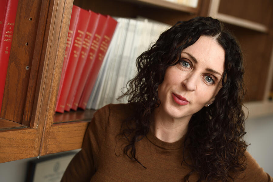 Kratom researcher Kirsten Smith stands in front of a bookcase