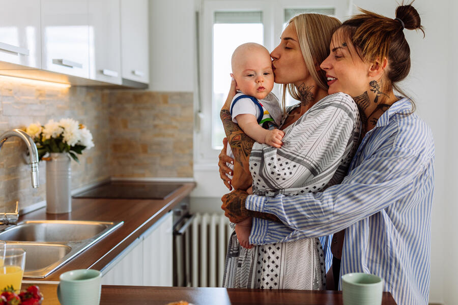 Two mothers in their kitchen with their infant