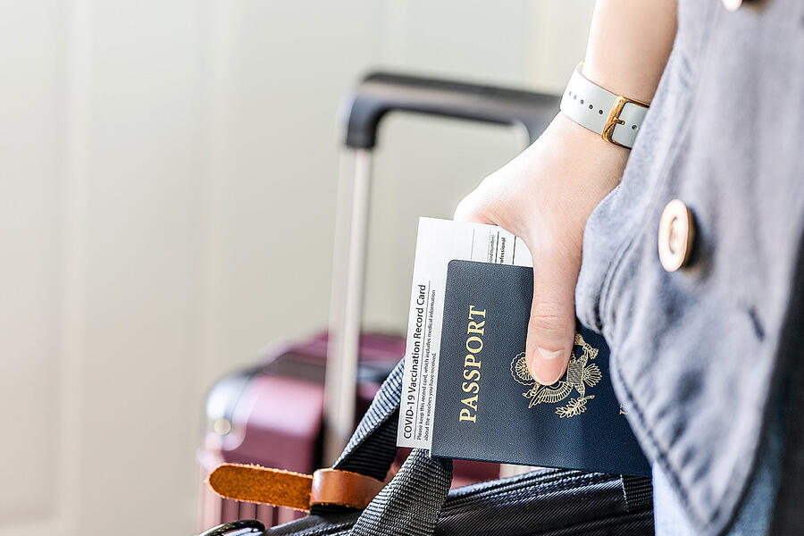Traveler holding a passport and suitcase