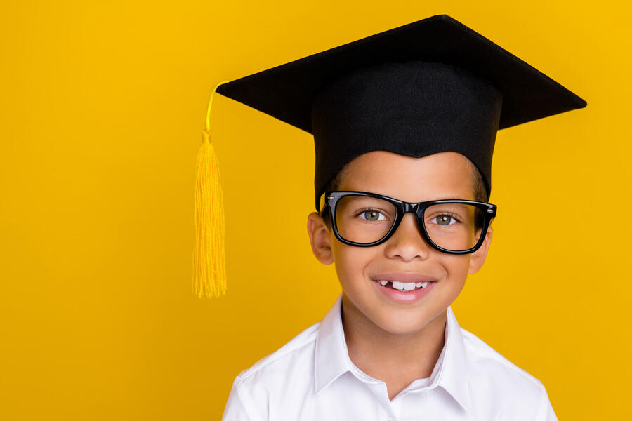 Smiling young boy wearing a mortarboard
