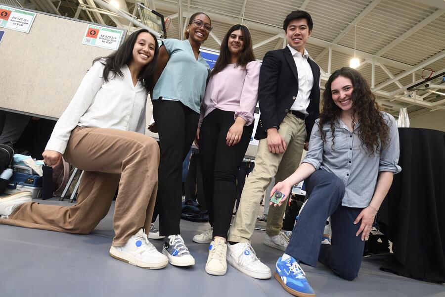 A group of five college students show off the Chirp Charm alarms on their sneakers.