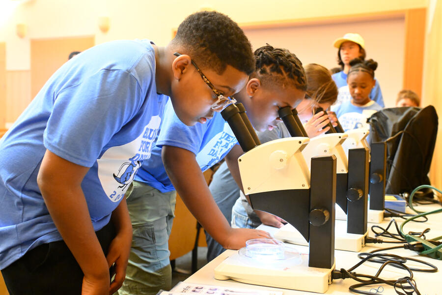 Young visitors looking through high-powered microscopes