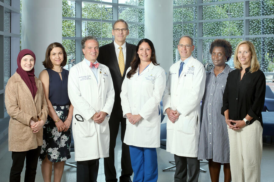 A team of eight people pose for a photo