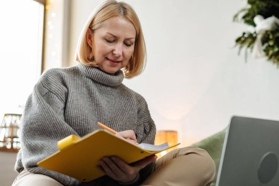 Woman writes in her journal what she is grateful for.