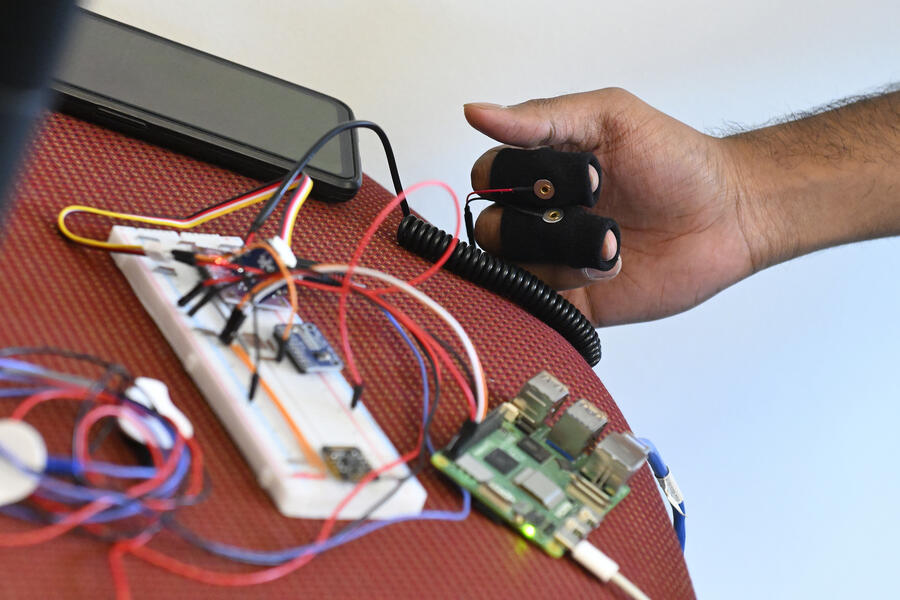 A close-up photo of a student's arm as they demonstrate the cybersecurity of a medical device