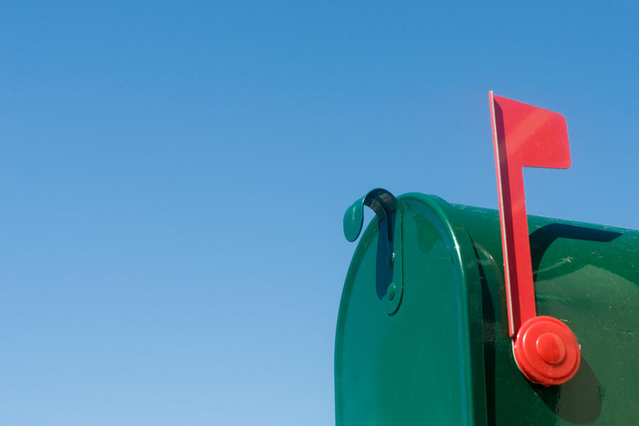 Rural mailbox with flag raised to indicate mail inside