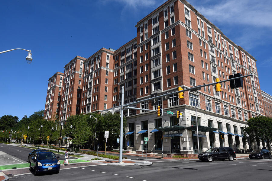 A multistory brick building is seen at a city intersection