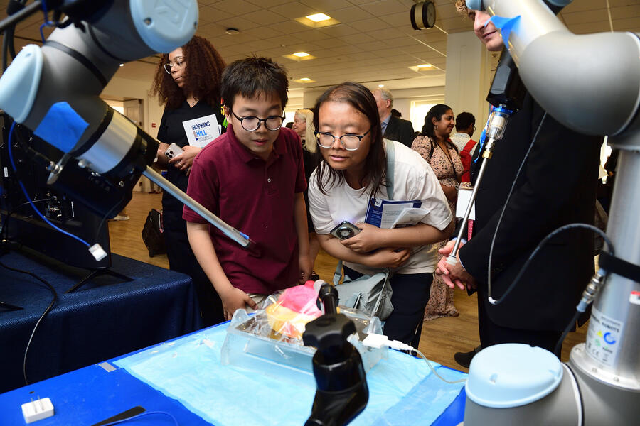 Two people watch a surgical robot demonstration.