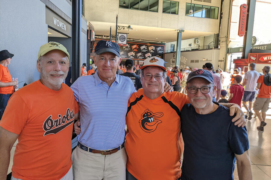 From left: Paul Andrews, Phil Kiester, Monroe Zeffert, and Mark Miller stand together in front of a merchandise store at Camden Yards