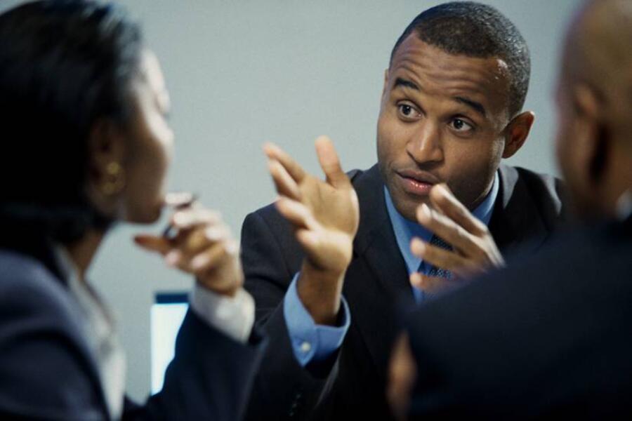 Man in a business suit talking with a co-worker