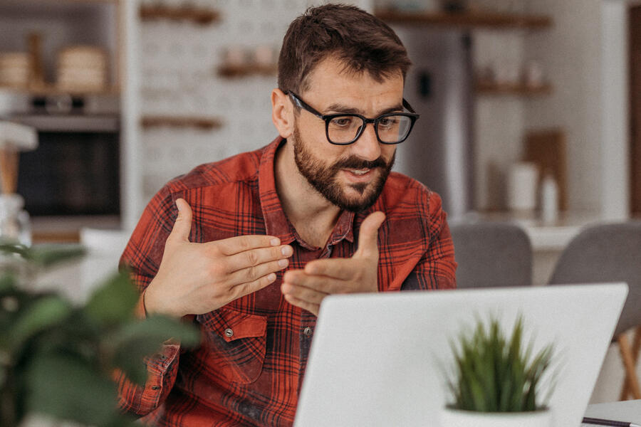 Man at laptop having a virtual conversation.