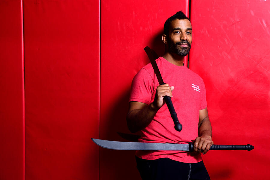 Tariq Mansour holding two martial arts weapons