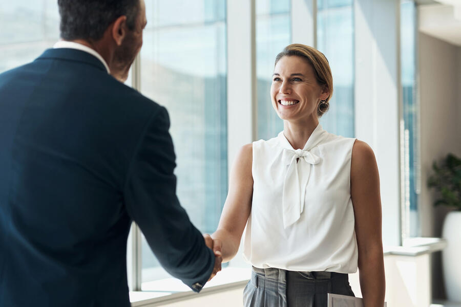 Mn and woman shaking hands before they meet to discuss retirement plans
