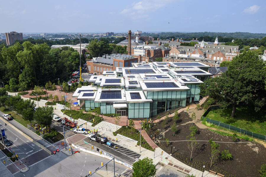An aerial shot of a large building situated among red brick paths on a college campus