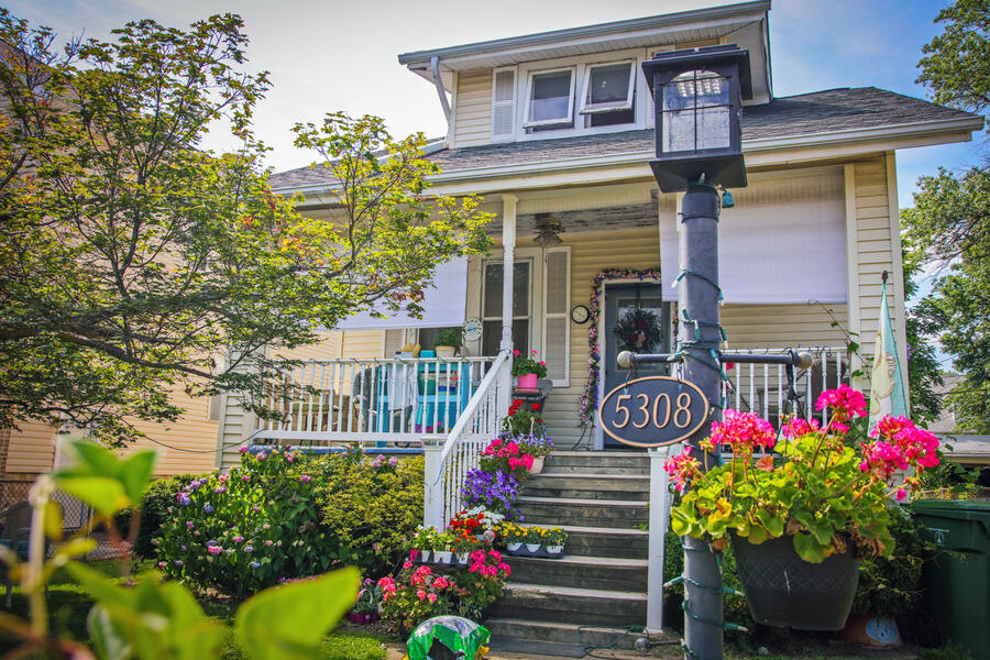 A house in Hamilton, one of the Northeast Baltimore neighborhoods on the Oct. 4 Trolley Tour route. It has a charming front porch and has many pots of colorful flowers.