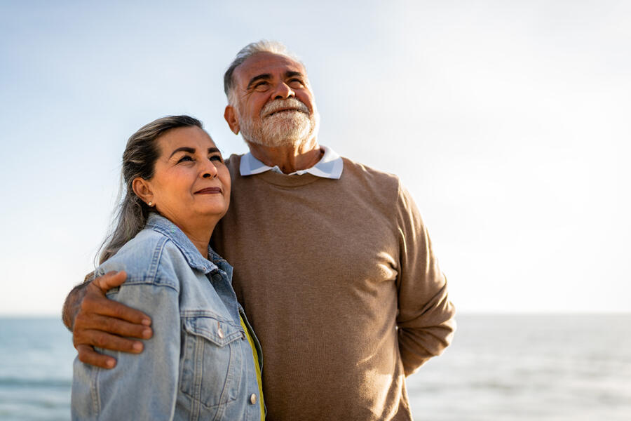 Senior couple standing at water's edge on a beach