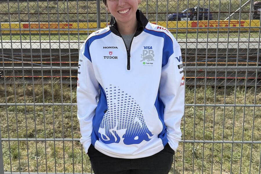 Talia Hovsepian smiles for a photo at a Formula 1 race.