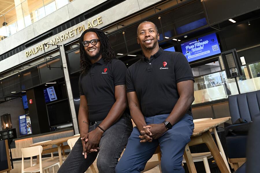 Khari and Shawn Parker smile for a photo in the Bloomberg Student Center's food hall.