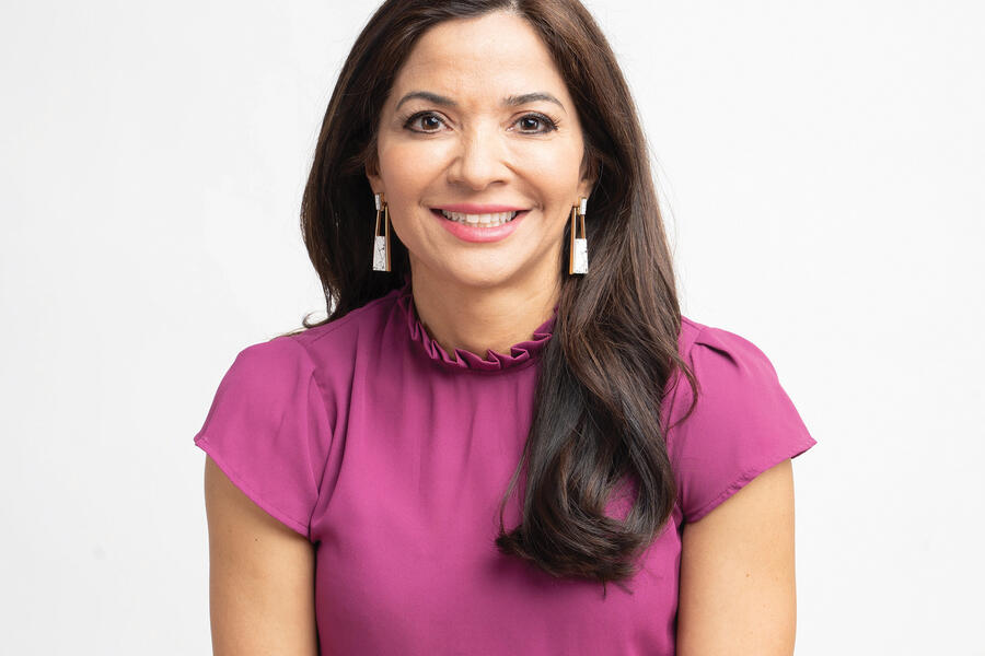 Photo of Selena Rezvani, who has long, dark hair and is wearing a pink shirt