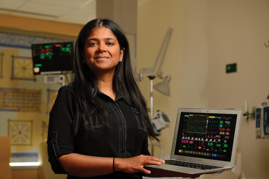 Suchi Saria with a laptop computer