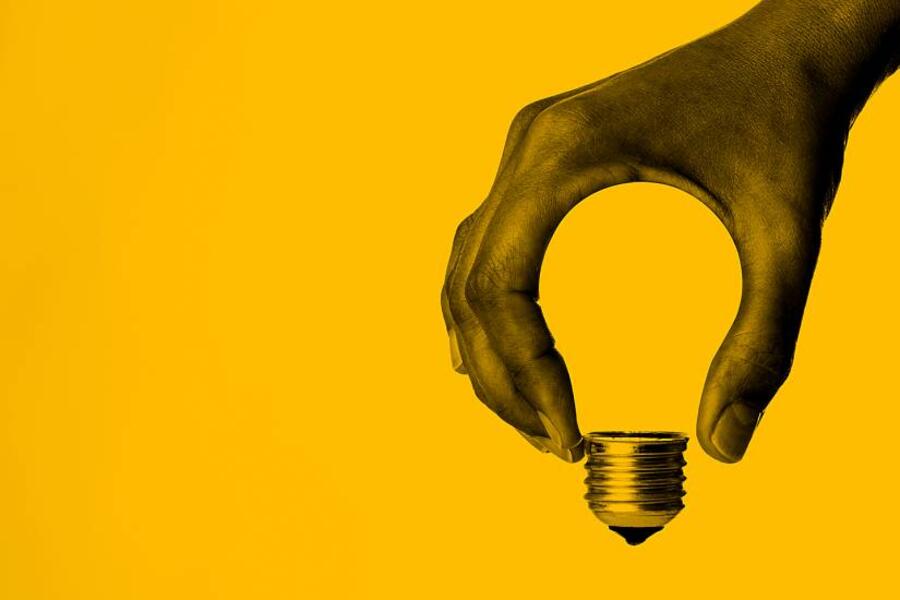 Creative representation of a hand holding a lightbulb