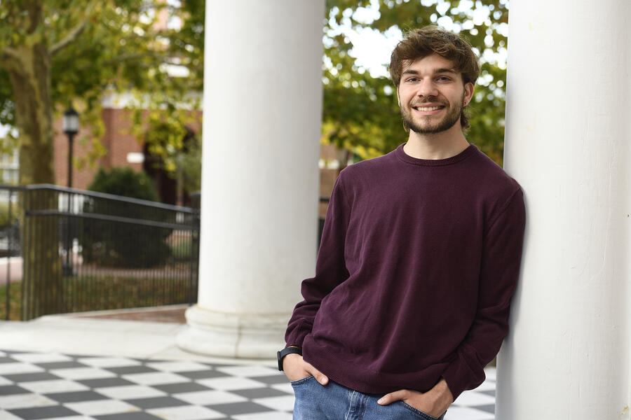 Trace Terrell leans against a white column as he smiles for a picture.