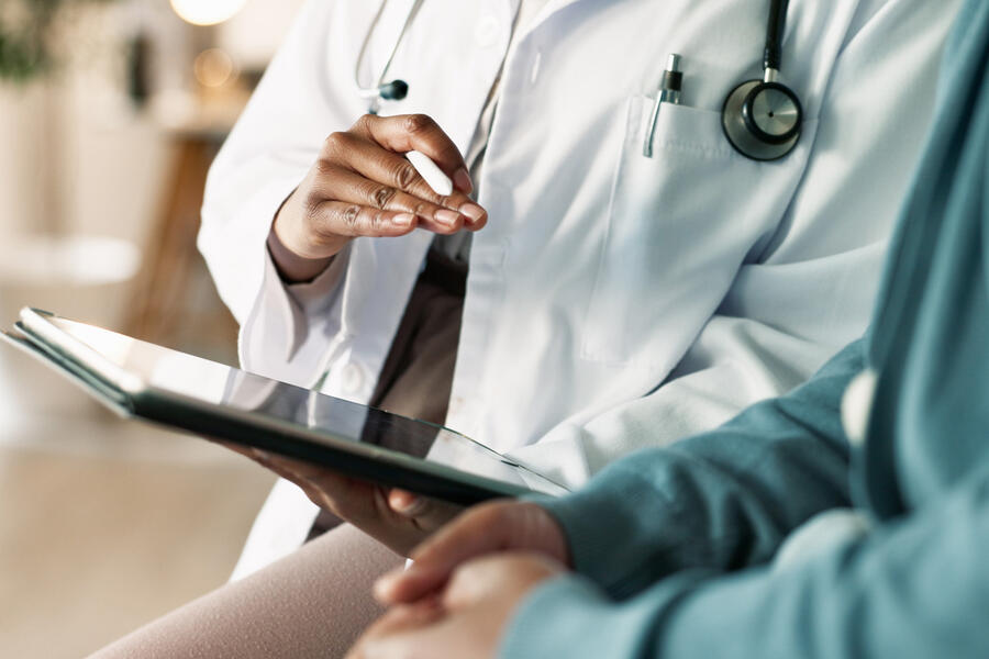 Physician looking at a tablet with his patient.