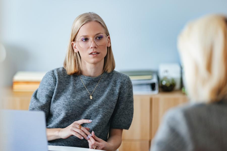 Two women having a conversation in an office.