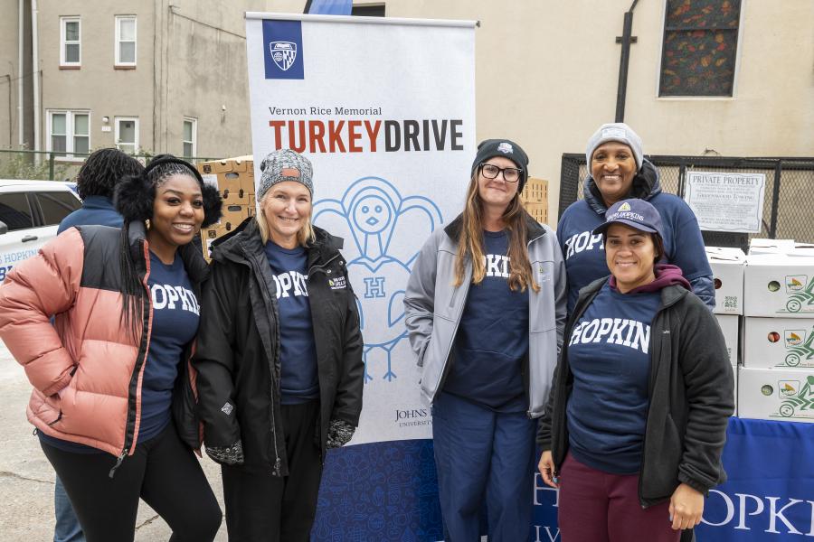 Hopkins volunteers pose by the turkey drive banner